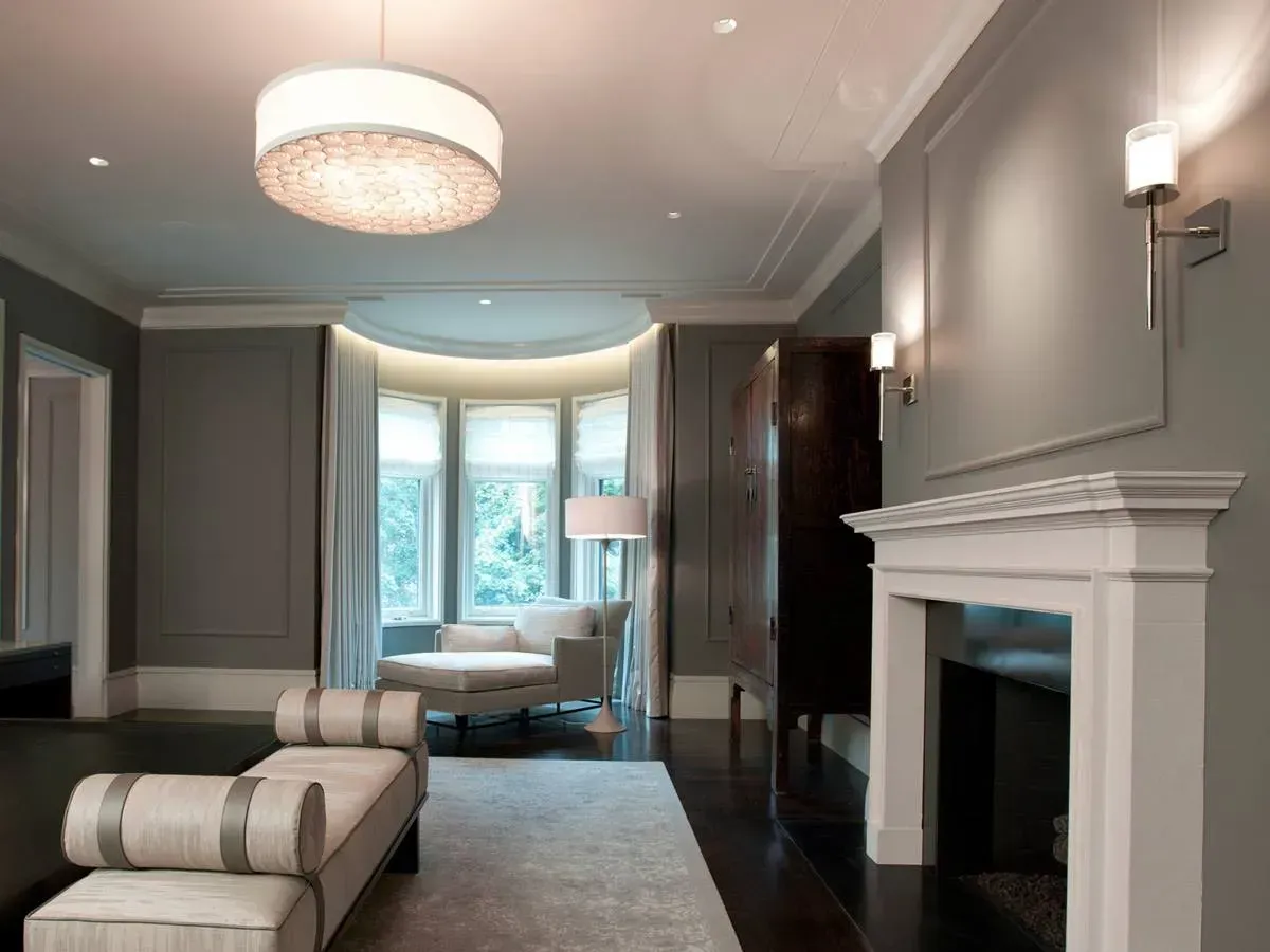 Elegant gray bedroom with chaise lounge, fireplace, and bay window seating area