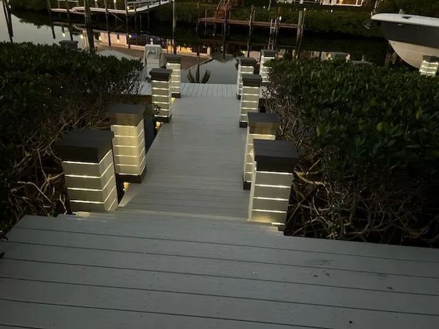 Wooden boardwalk path with striped posts leading over dark water through dense marsh plants
