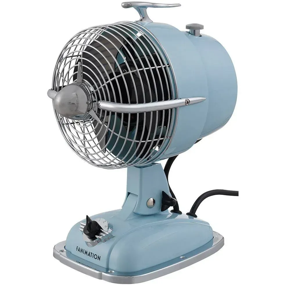 Vintage light blue metal desk fan with chrome grille and base on a stand.