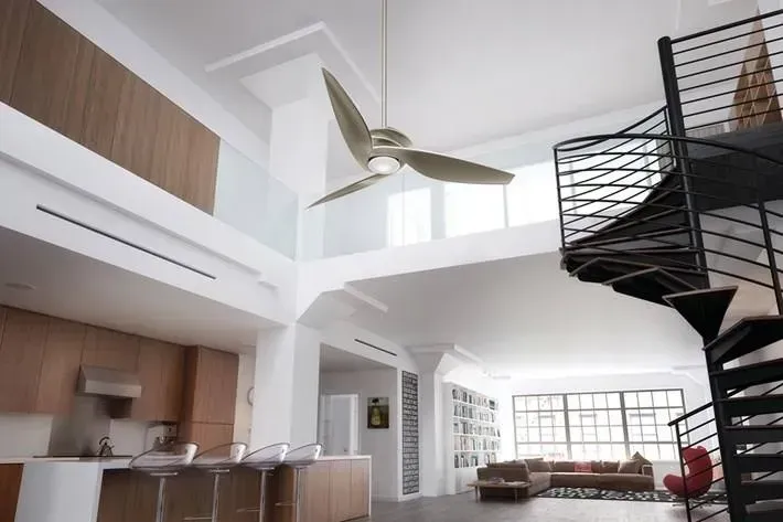 Bright modern loft with open kitchen, living area, and spiral staircase in a white interior.