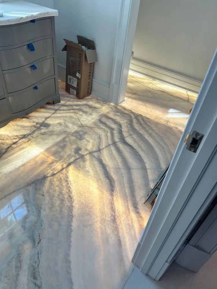 Sunlit hallway with wavy light reflections on the floor and an open doorway to the right