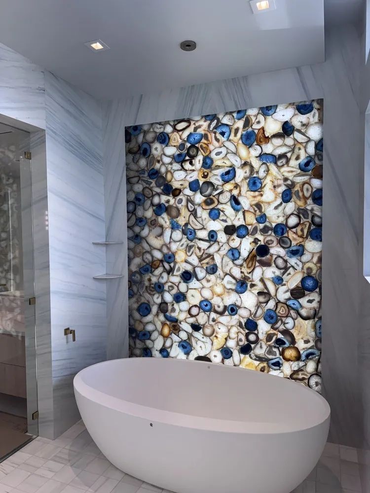 Modern bathroom with freestanding oval tub and blue-and-white mosaic accent wall