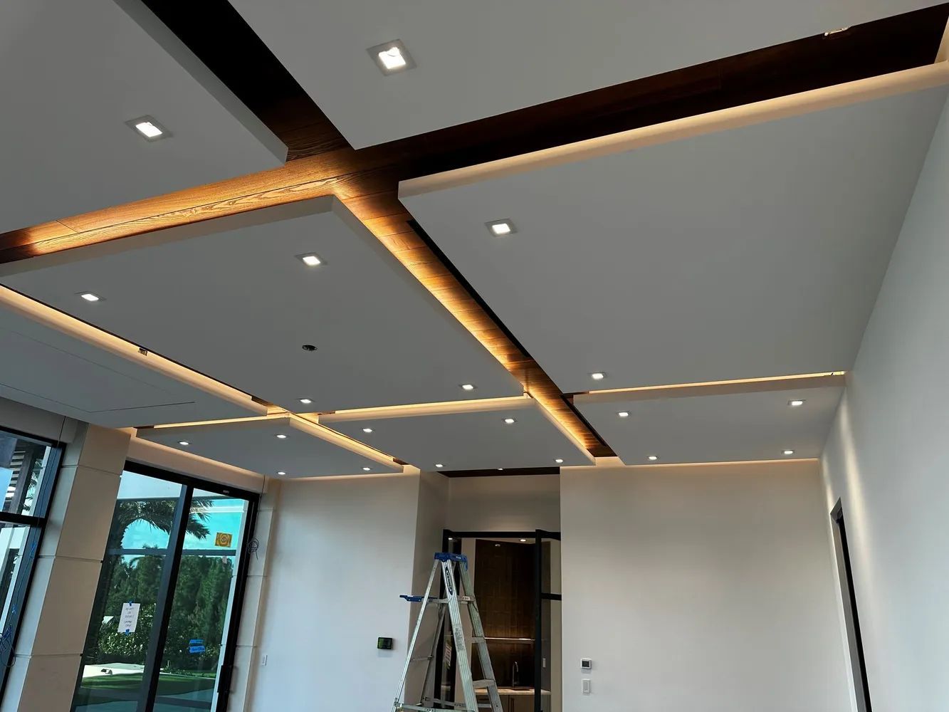 Ceiling under construction with recessed lights and ladder in a modern room