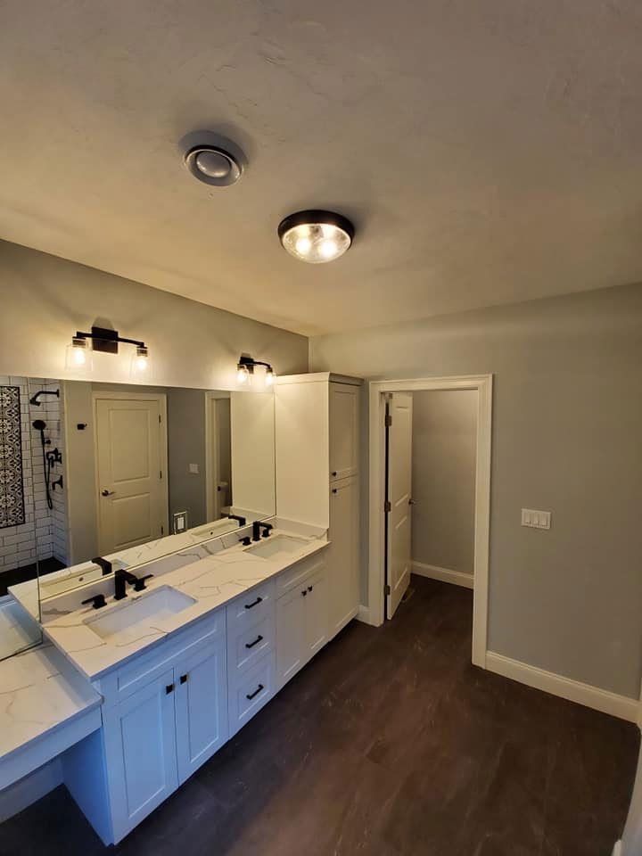 Bathroom with white cabinetry, marble countertops, dark wood floor, and a walk-in closet.