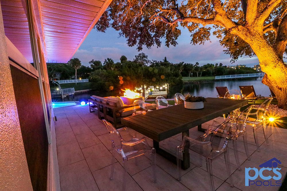 A patio with a table and chairs and a fire pit
