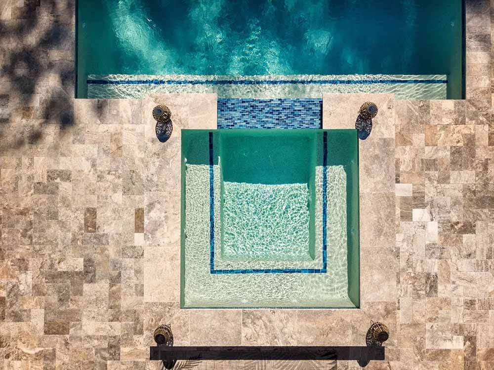 An aerial view of a swimming pool with a tiled floor.