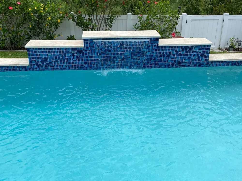 There is a waterfall in the middle of the pool.