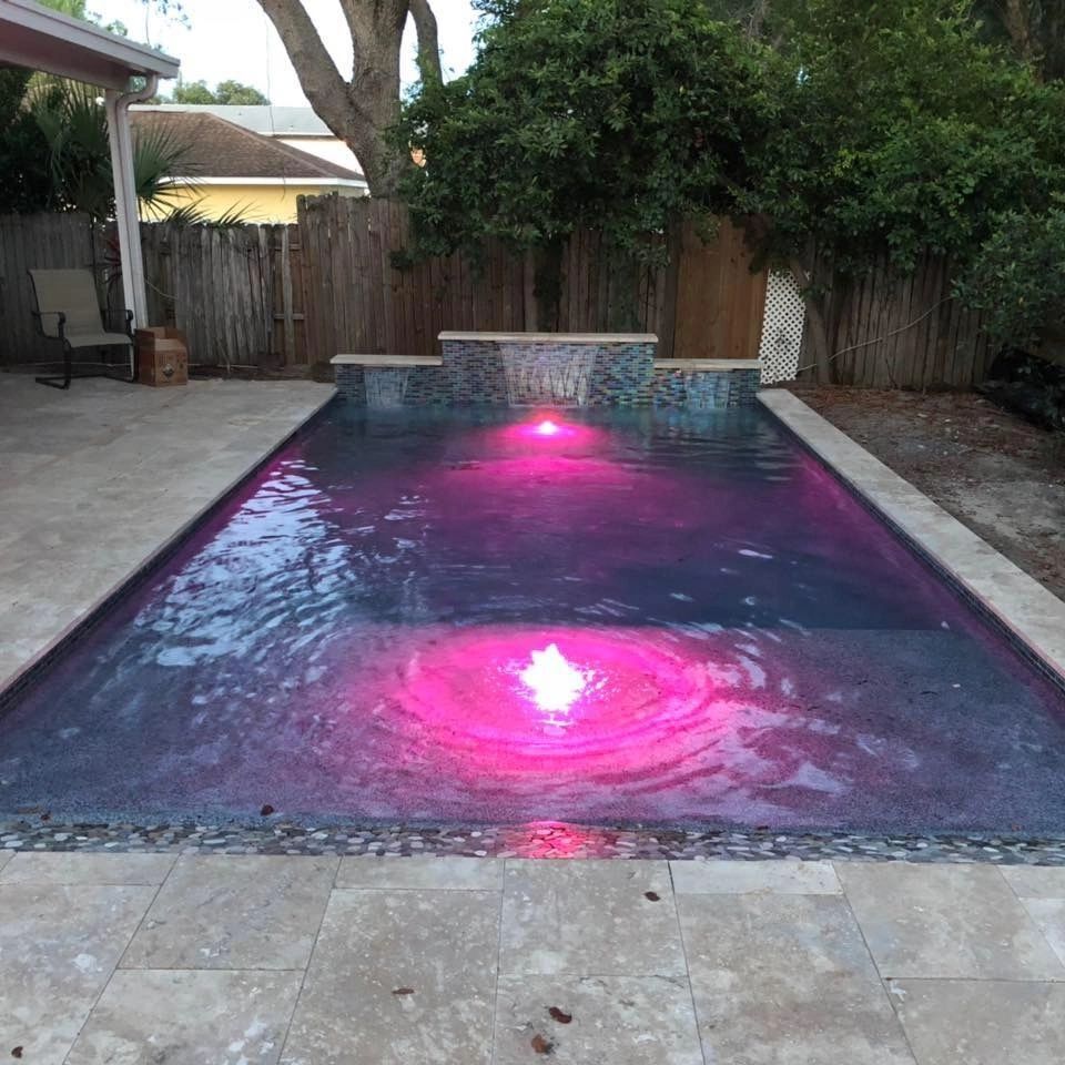A swimming pool with a pink light in the middle