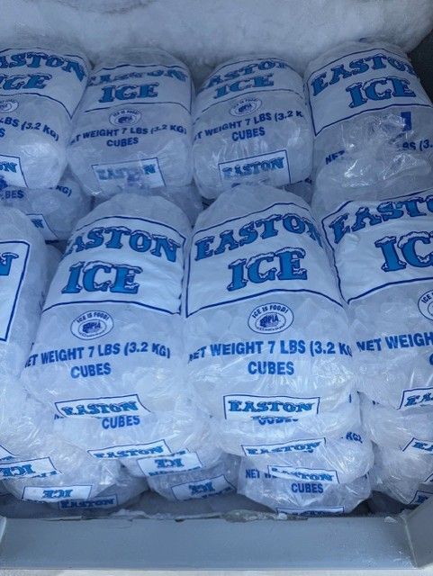 Stacked clear bags of Easton ice cubes in a freezer bin