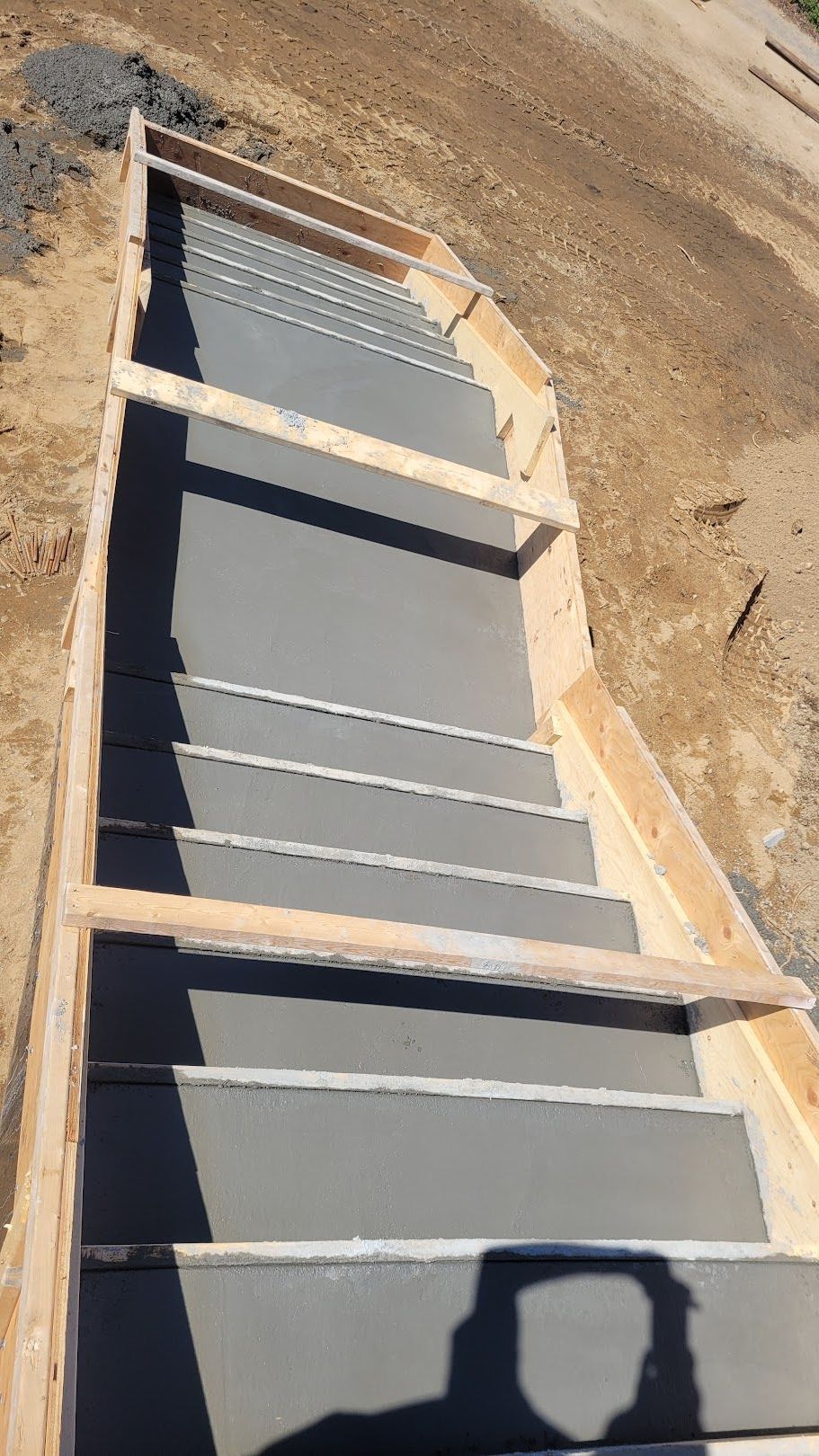 A person is taking a picture of a concrete staircase being built.