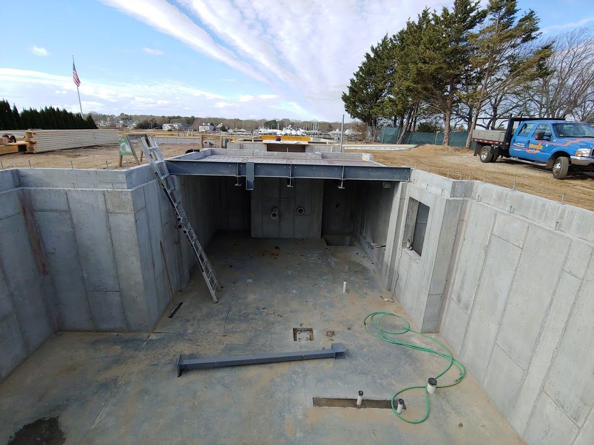 A concrete basement under construction with a blue truck parked in the background.