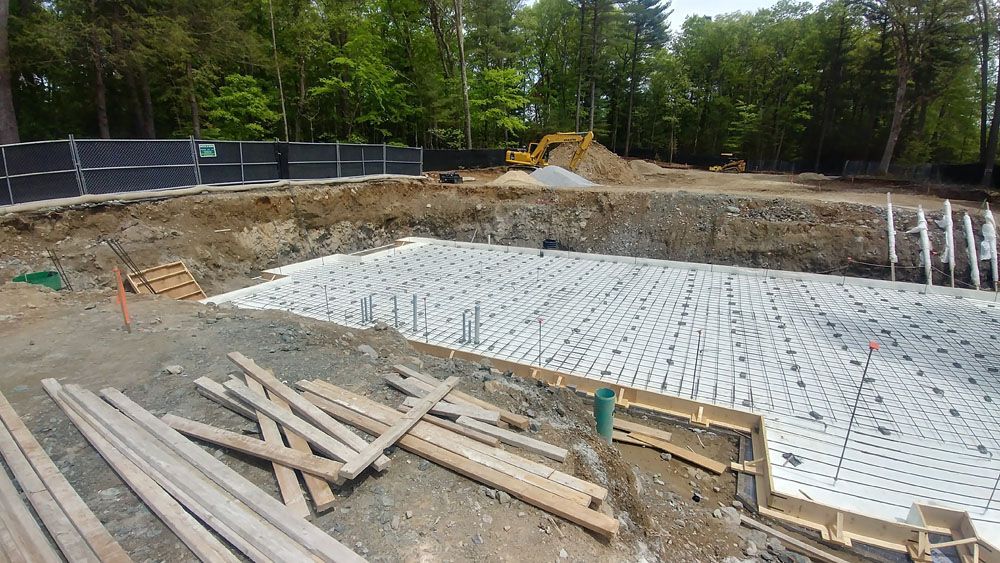 A large hole in the ground is being filled with concrete.