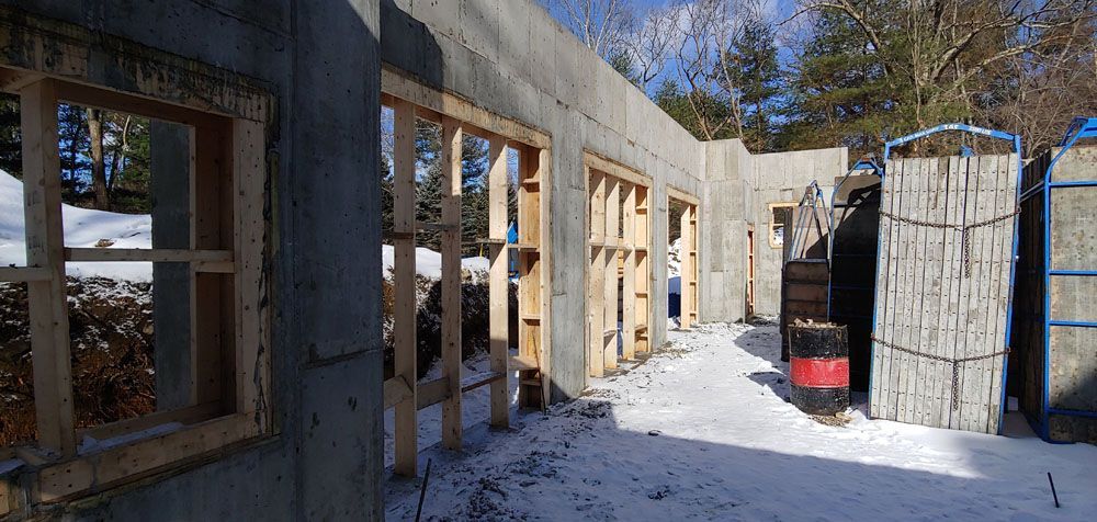 A building is being built in the snow with a lot of windows.