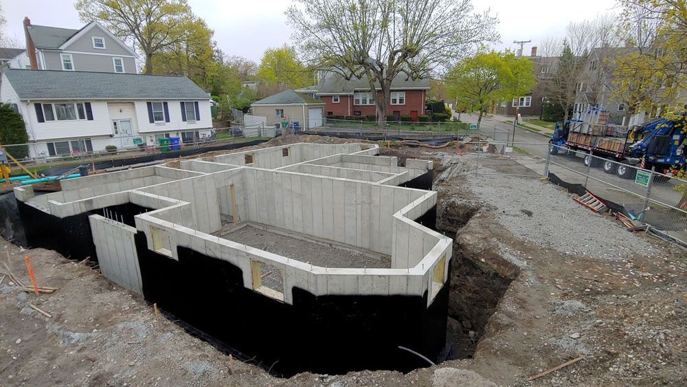 A concrete foundation is being built in front of a house.