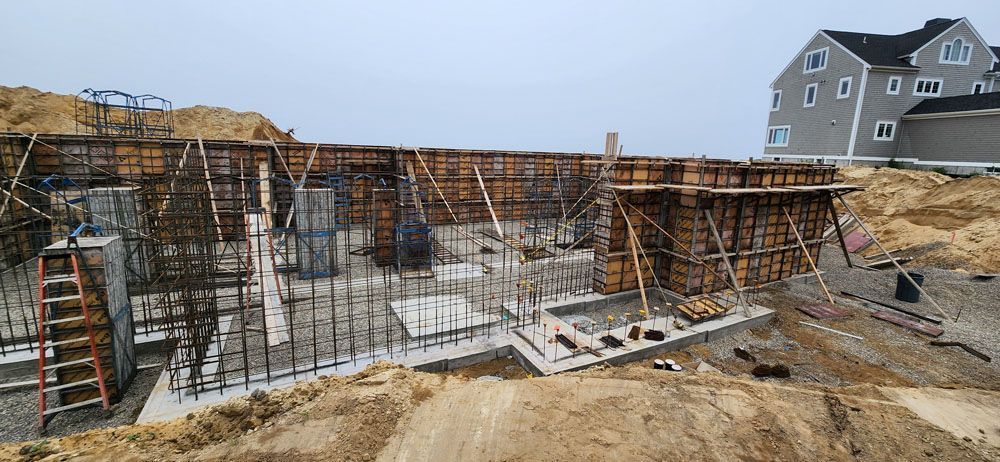 A construction site with a house in the background and a ladder in the foreground.