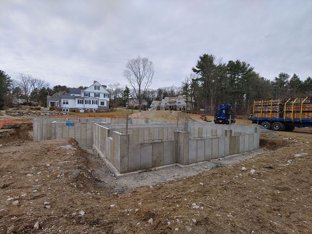 A large concrete foundation is being built in a dirt field.