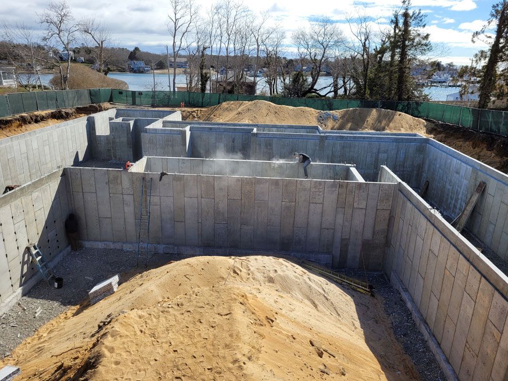 A pile of dirt is sitting in front of a concrete wall.