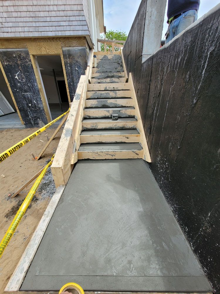 A set of concrete stairs being built in front of a house.