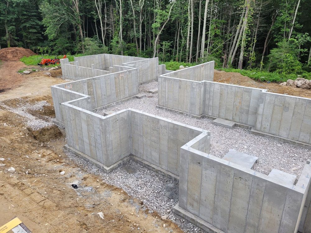 A large concrete structure is being built in the middle of a dirt field.