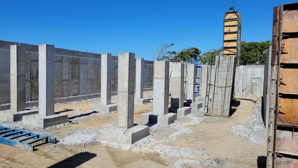 A row of concrete pillars are being built on a construction site.