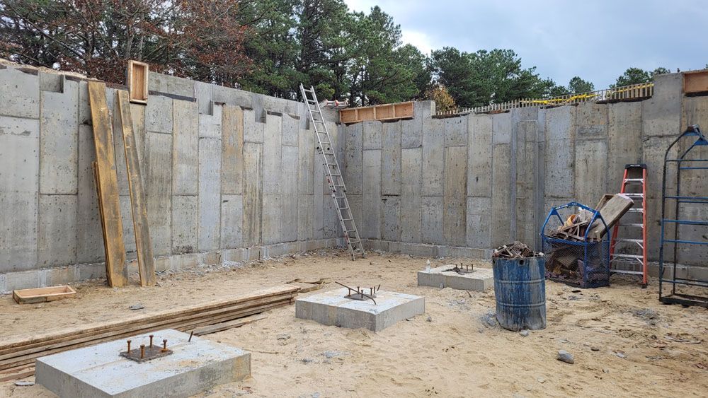 A concrete wall is being built in a construction site.