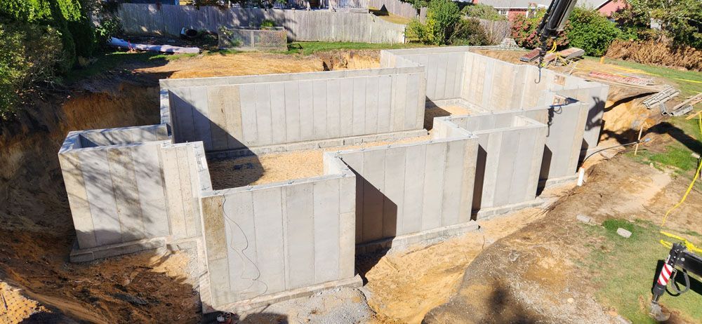 An aerial view of a concrete foundation being built in a backyard.