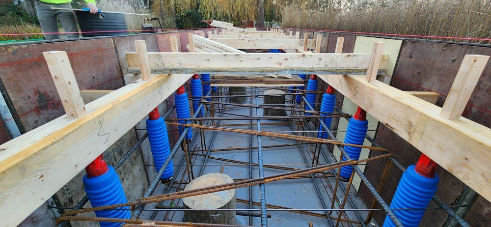 A construction site with wooden beams and blue pipes.