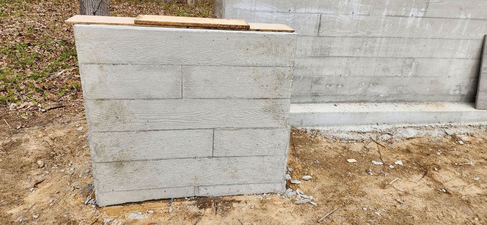 A concrete wall is being built in the dirt.