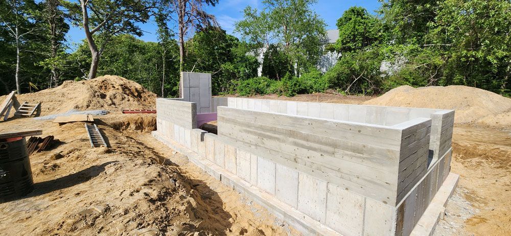 A concrete foundation is being built in a dirt field.