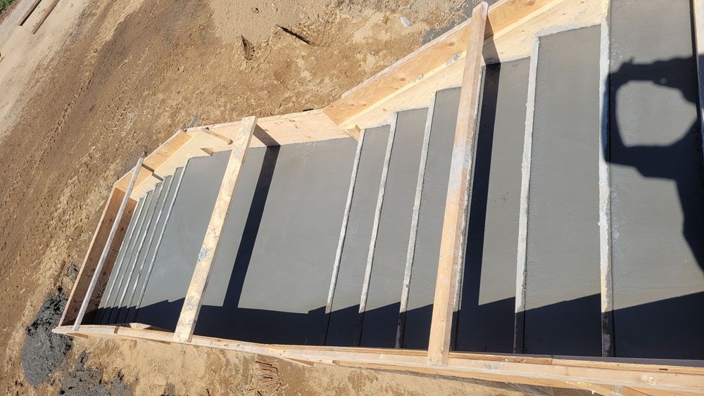 A concrete staircase is being built on top of a dirt hill.