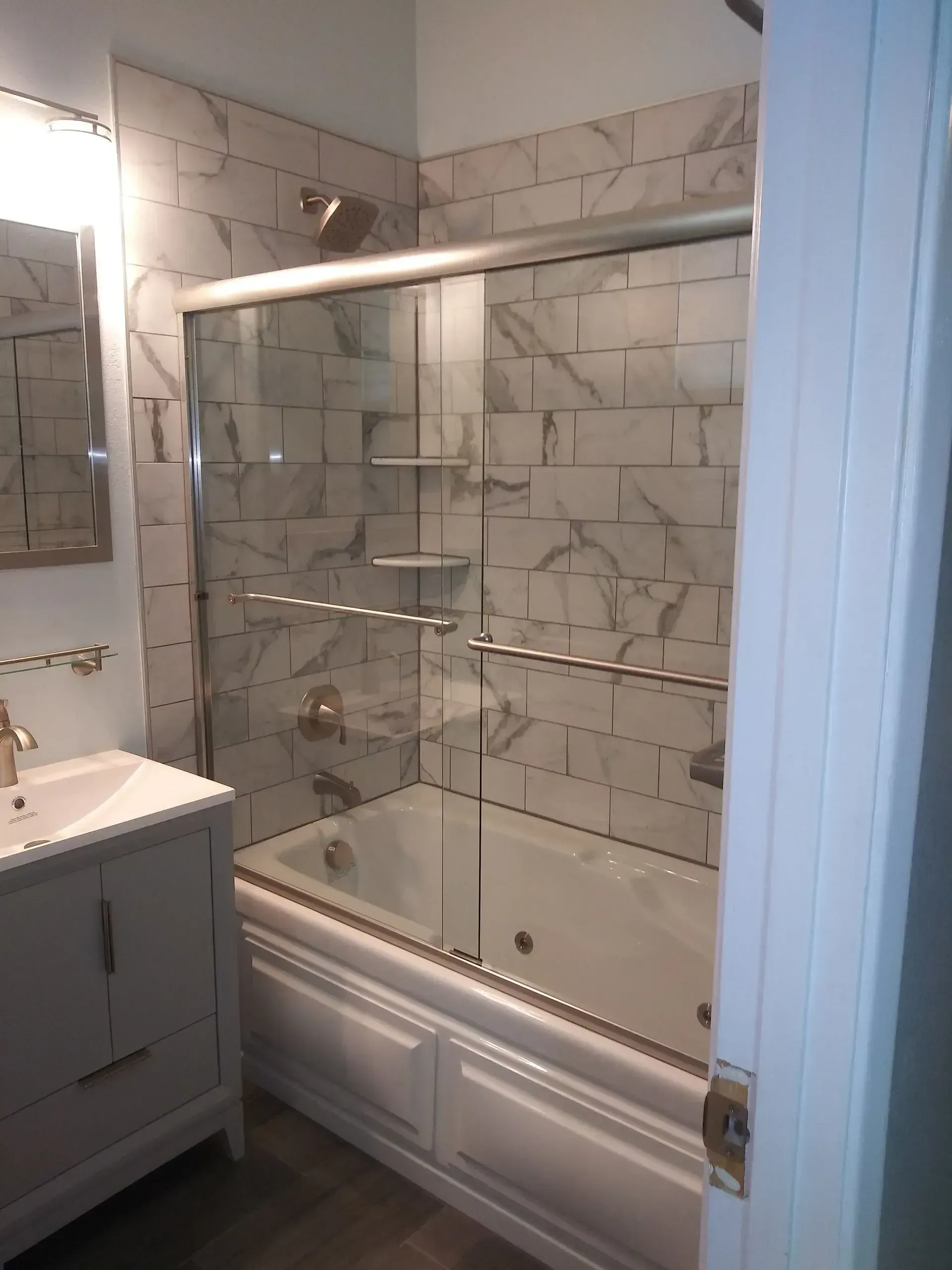 A bathroom with a bathtub a sink and a mirror