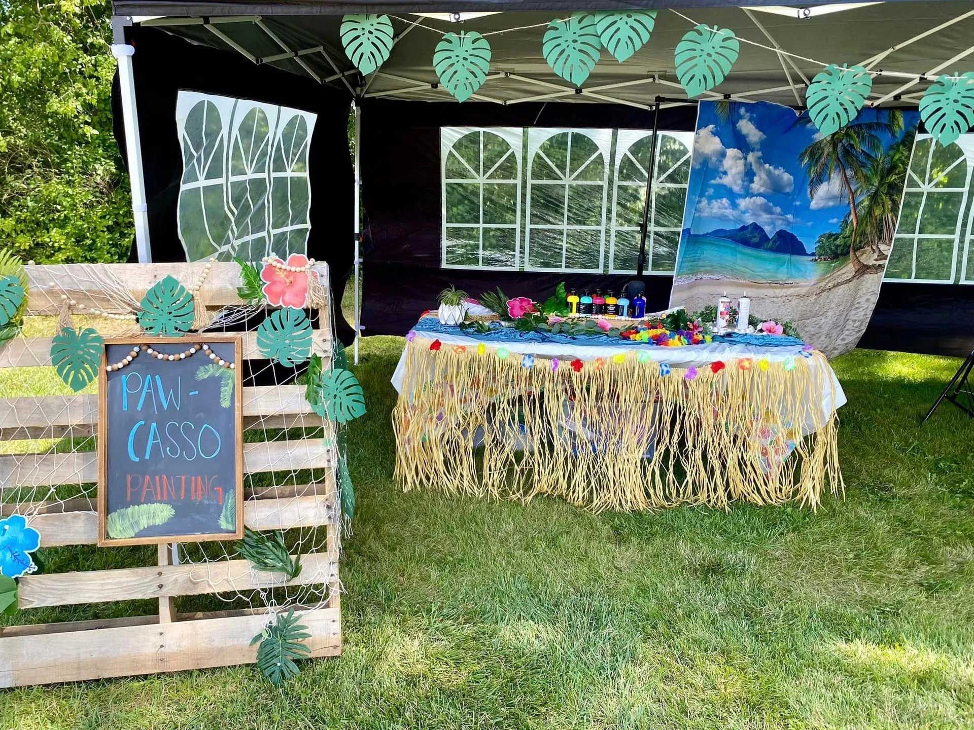A tropical-themed party setup with a pallet sign reading 