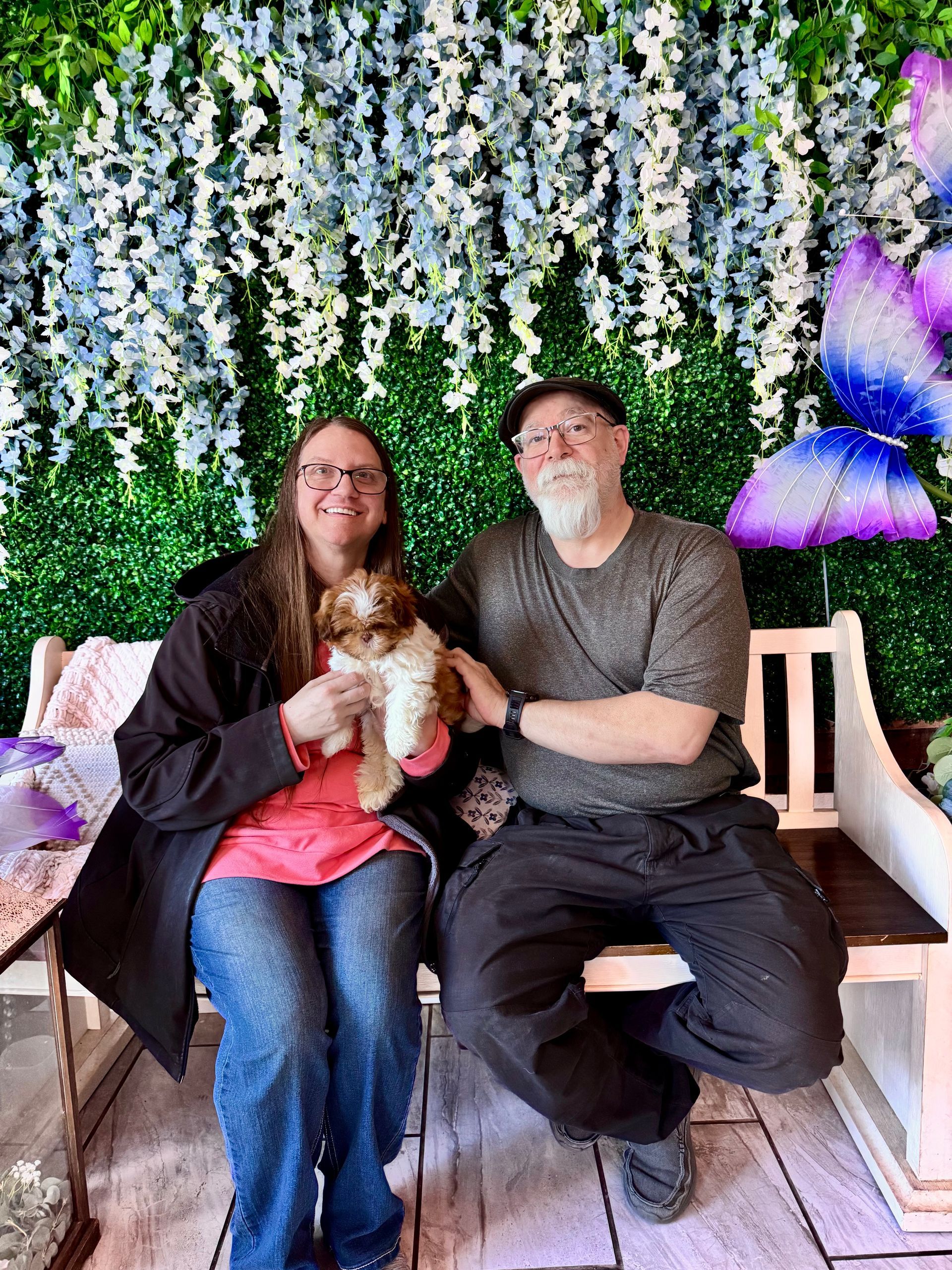 Six people posing together in front of a decorated house entrance, smiling at the camera.