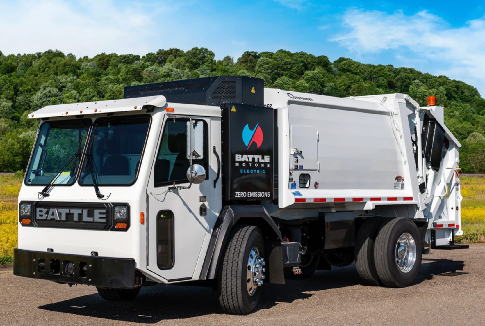 A white garbage truck is parked on the side of the road.