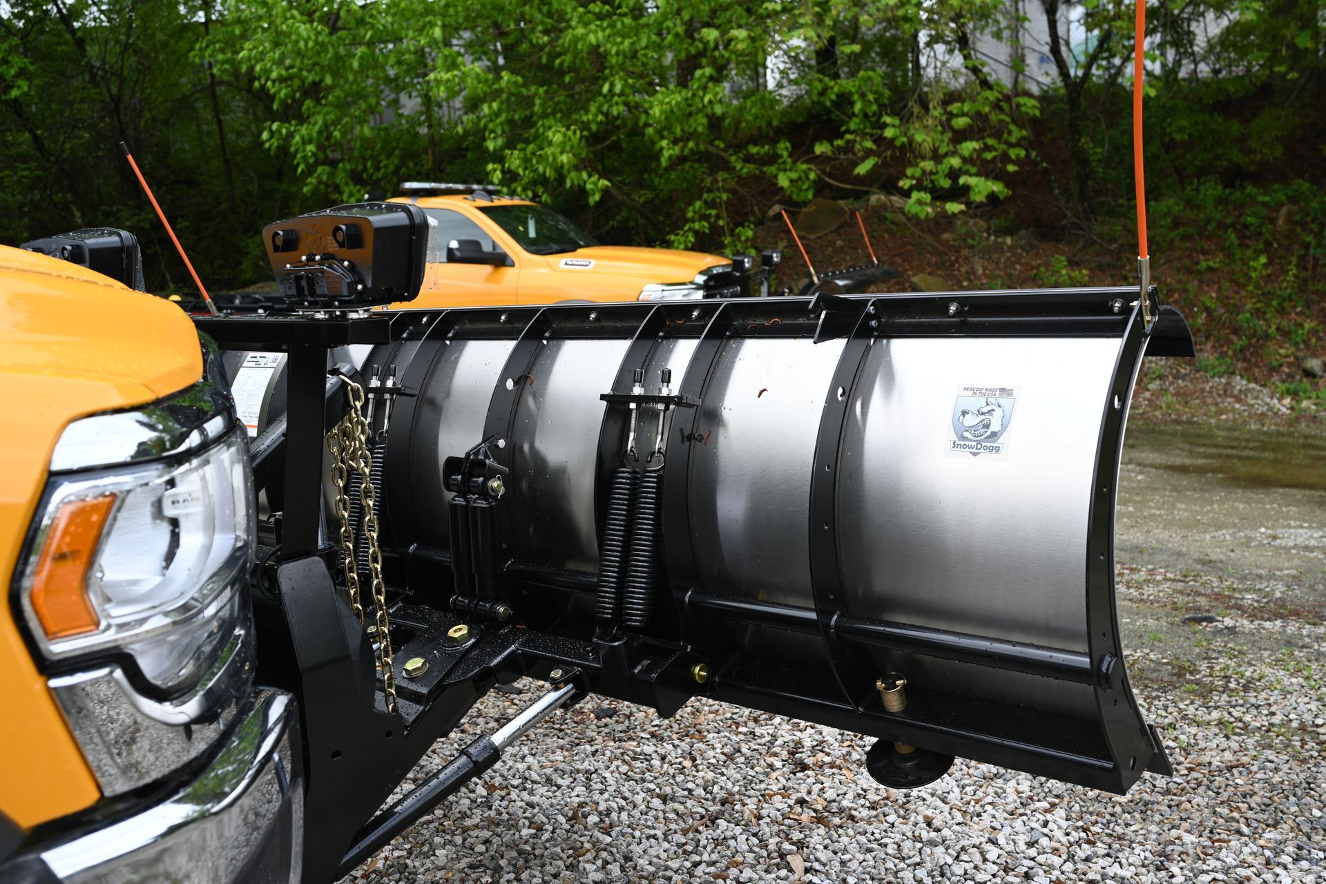 A yellow truck with a snow plow attached to the front of it.