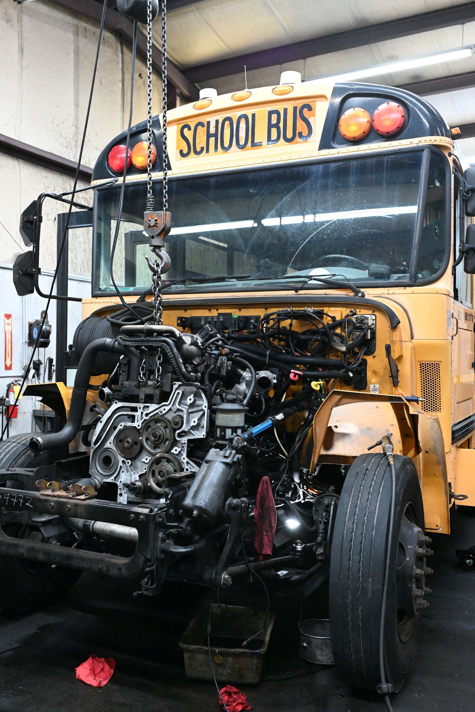 A school bus is being repaired in a garage.