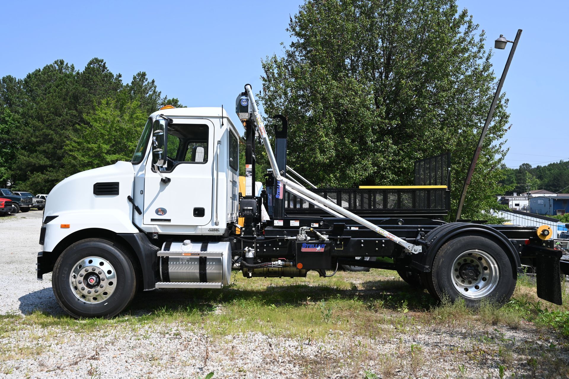 A white dump truck is parked in a gravel lot.