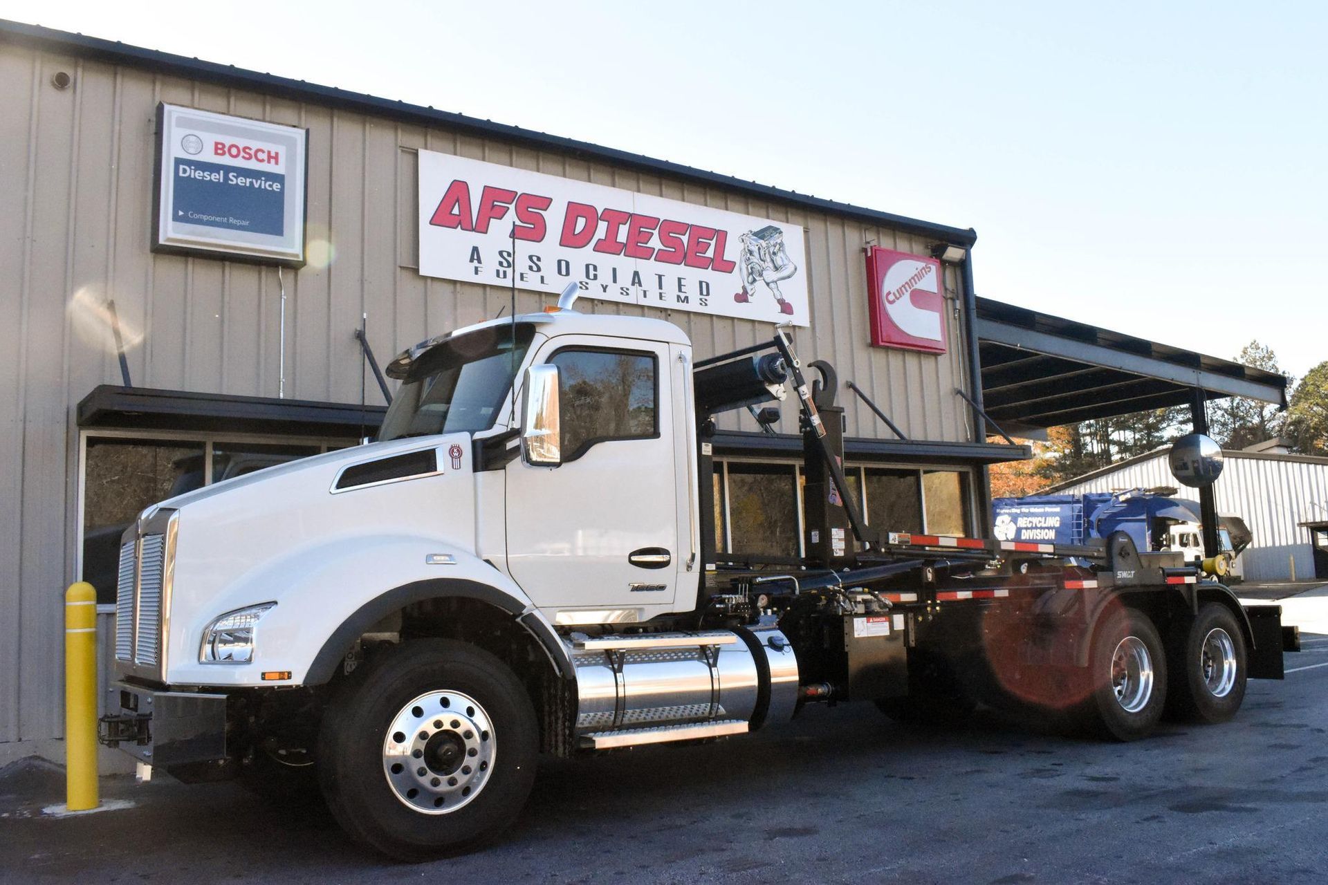 A white semi truck is parked in front of a building.