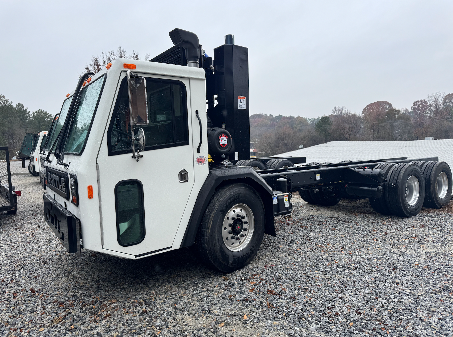 A white dump truck is parked in a gravel lot.