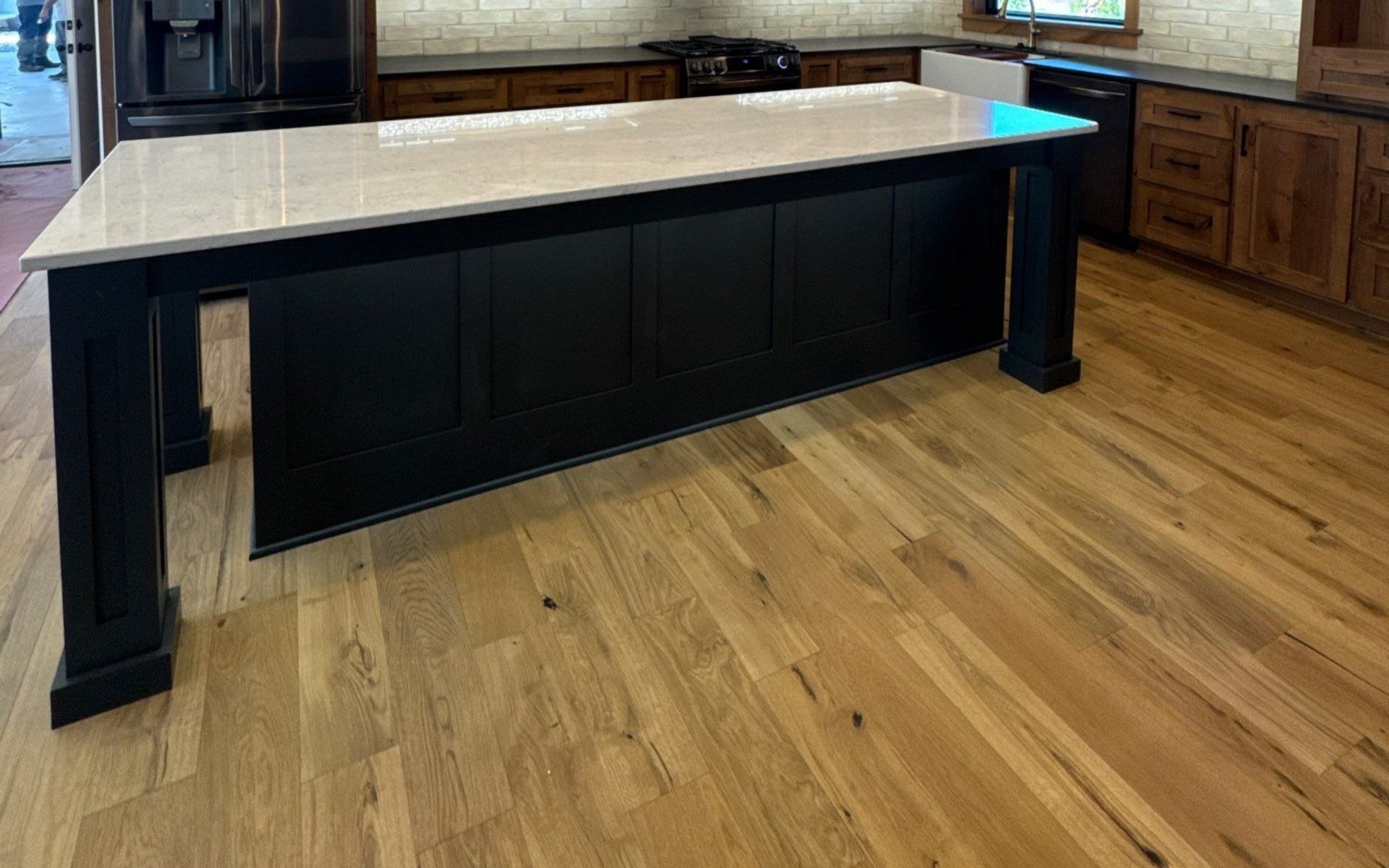 Empty room with wood-look flooring, white trim, and beige walls.