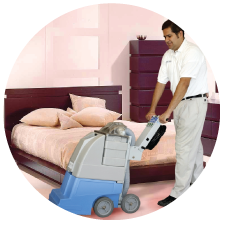 a man is cleaning a bed with a vacuum cleaner