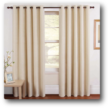 a pair of white curtains are hanging on a window in a living room .