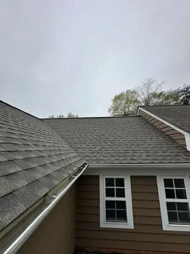 View from a rooftop between two gray-shingled houses on an overcast day