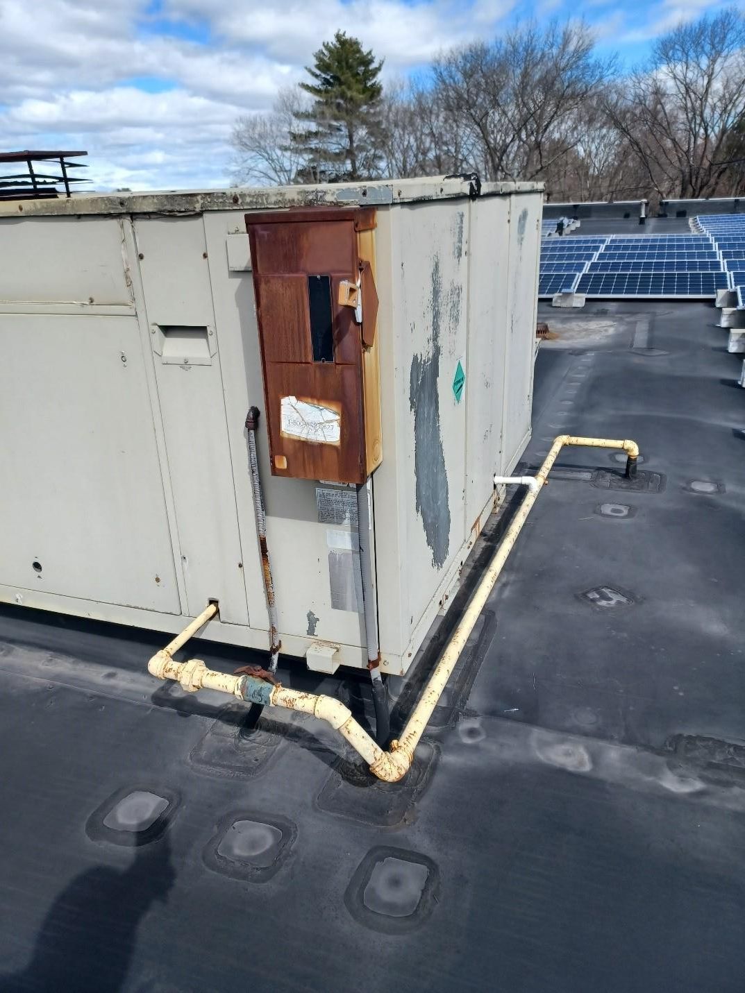HVAC unit on a black rooftop.