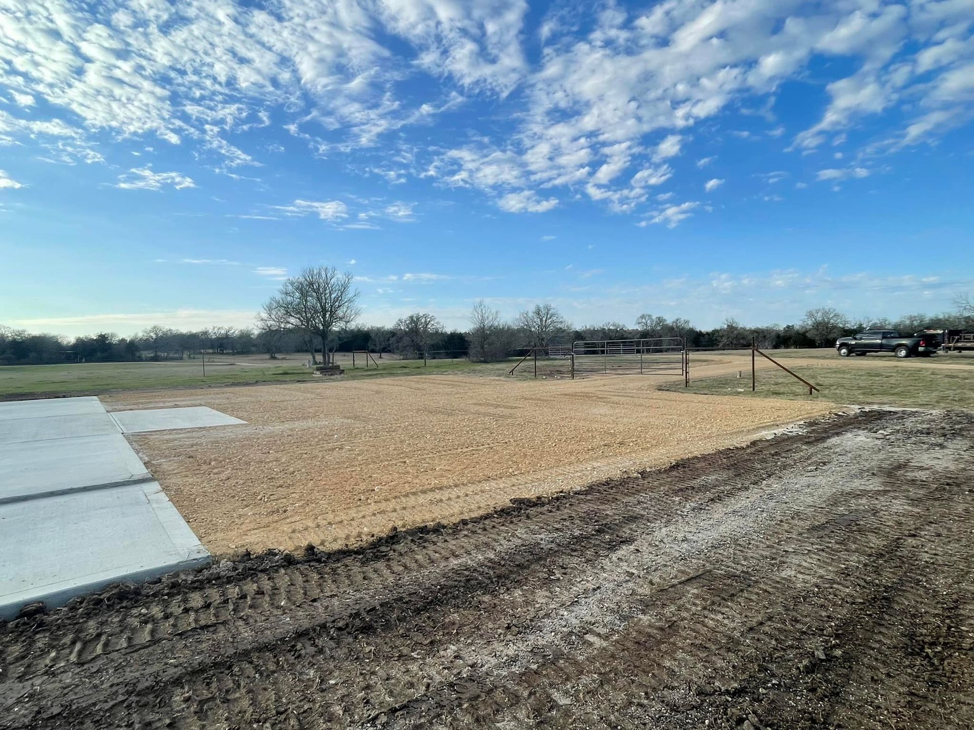 Construction site: gravel base, concrete pad, blue sky.