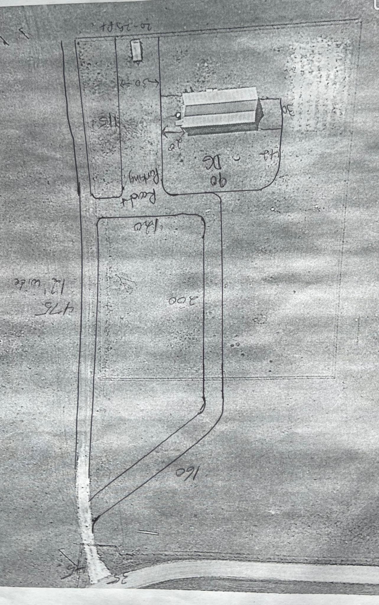 Overhead view of a building complex. Several structures, roads, and paths outlined in a grassy area.
