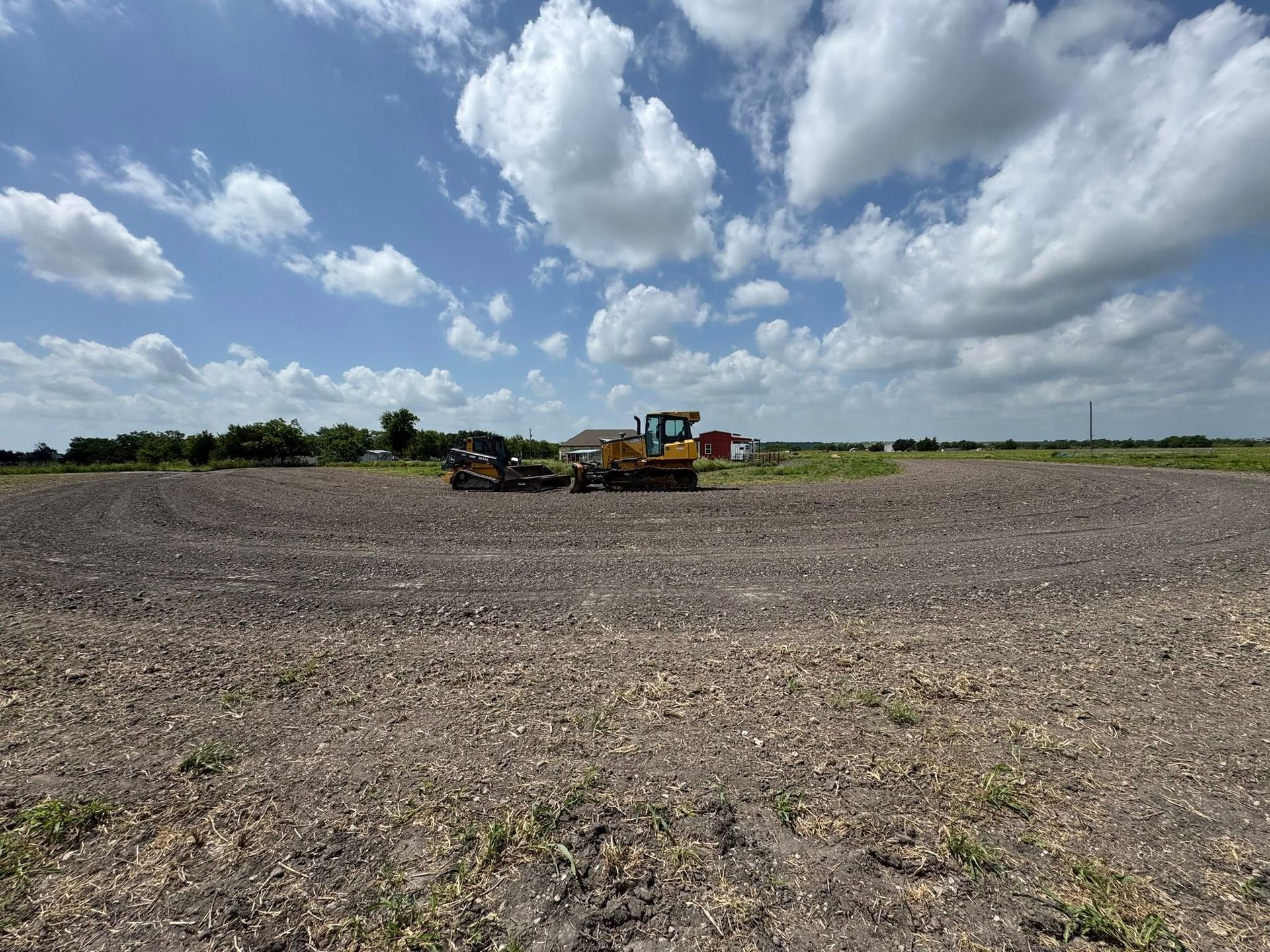 A bulldozer working in a field under a cloudy sky.