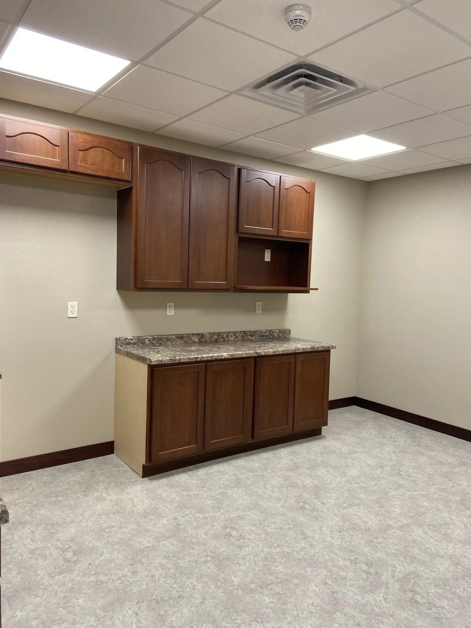 An empty room with wooden cabinets and a counter top.