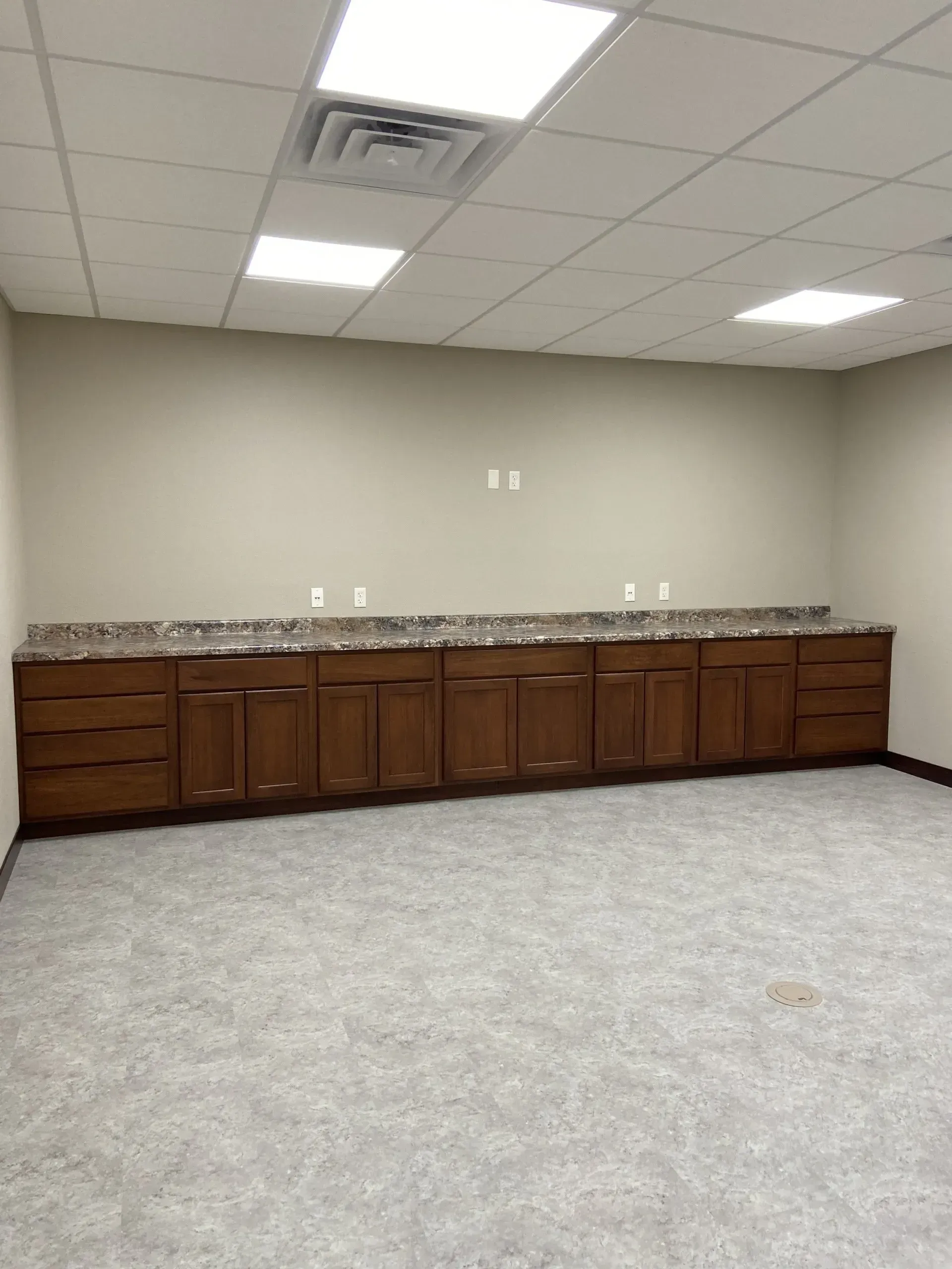 An empty room with wooden cabinets and granite counter tops.