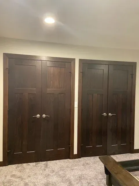 A living room with two wooden doors and a table.